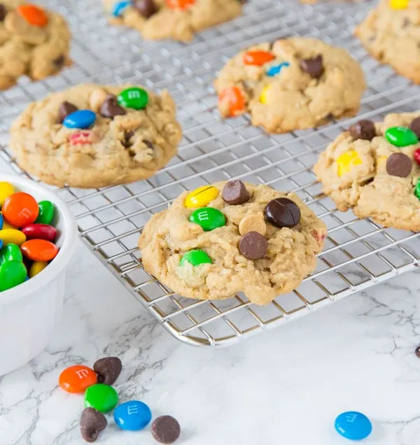 Soft Monster Cookies - a soft and chewy cookie that is a cross between a peanut butter cookie, an oatmeal cookie, and a chocolate chip cookie!  Full of lots of goodies everyone loves them!