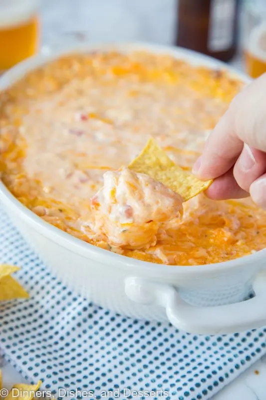 baked cheese dip in a dish with a chip full of dip