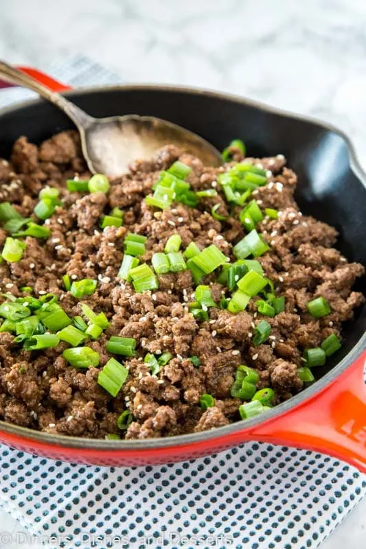 A skillet with mongolain ground beef topped with green onions