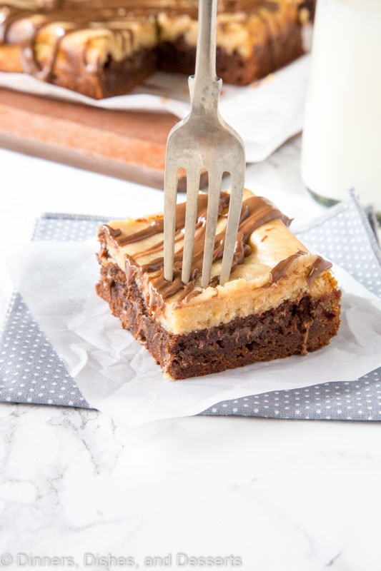 Peanut butter cheesecake brownie on a plate with a fork
