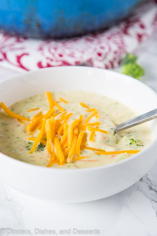 A bowl of broccoli cheese soup with spoon