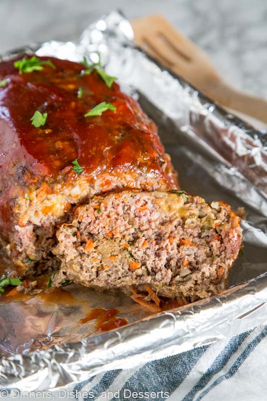 A close up of a piece of cake on a paper plate, with Meatloaf and Dinner