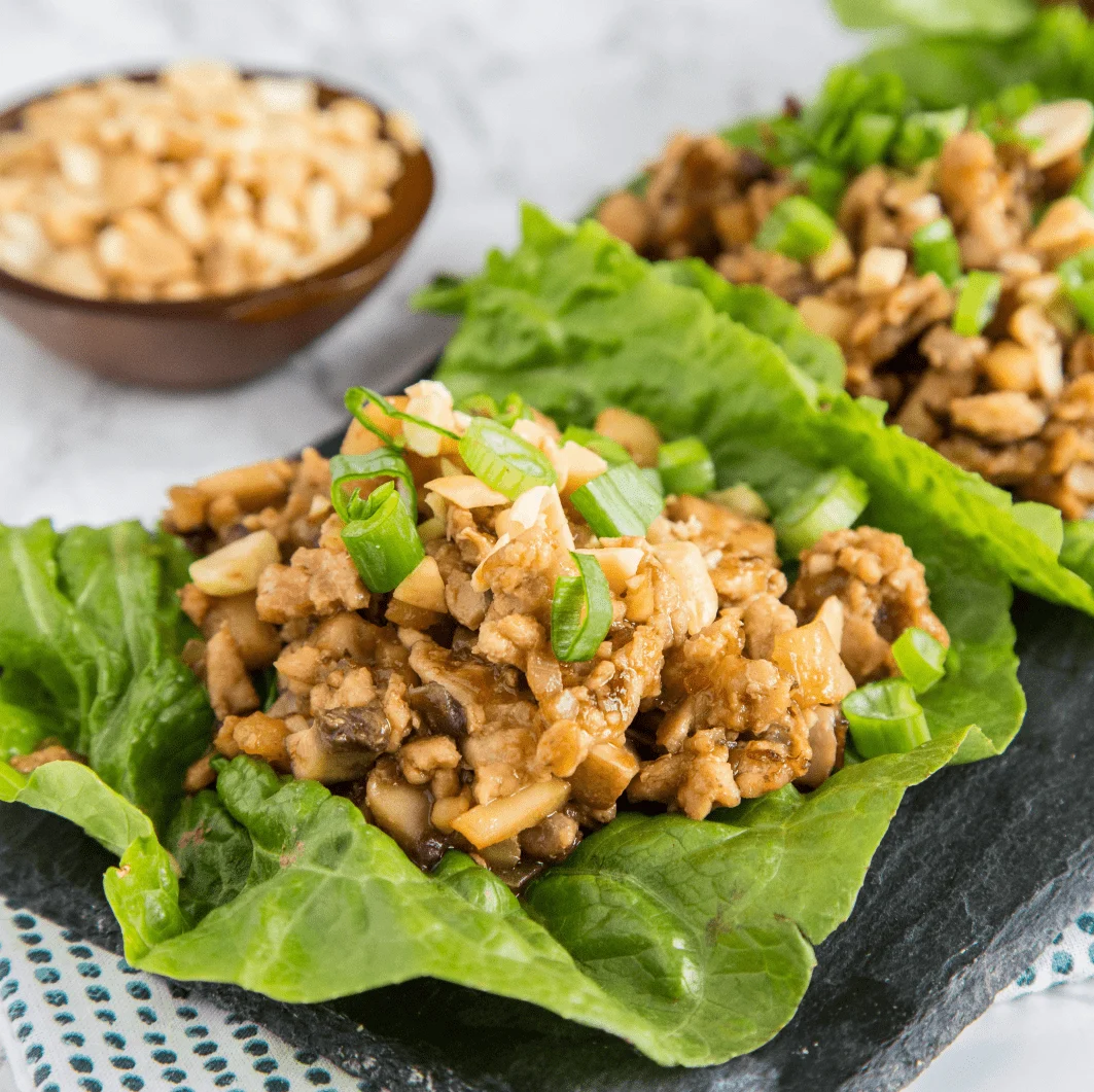 A plate of food, with chicken lettuce wraps