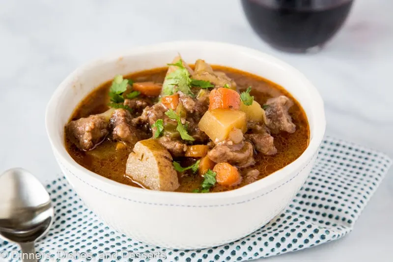 A bowl of food on a plate, with Stew and Beef