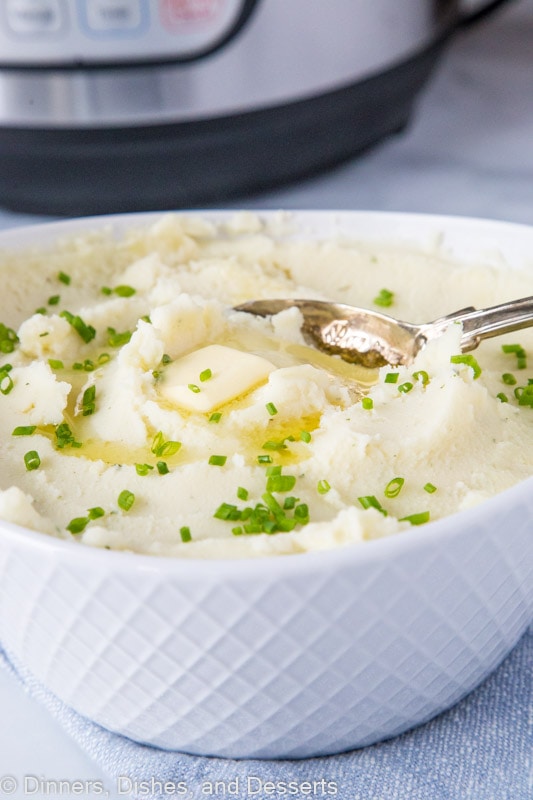 A bowl of mashed potatoes with a spoon