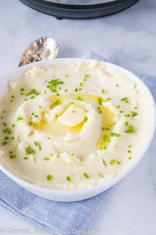 A bowl of mashed potatoes with butter and chives