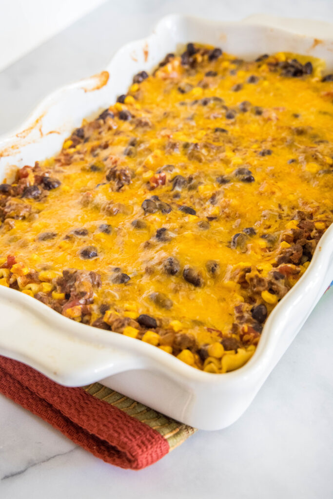 Baked Mexican lasagna in a white ceramic baking dish.