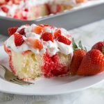 Strawberry Poke Cake - a classic poke cake with white cake, strawberry jello, whipped cream and lots of fresh strawberries! 