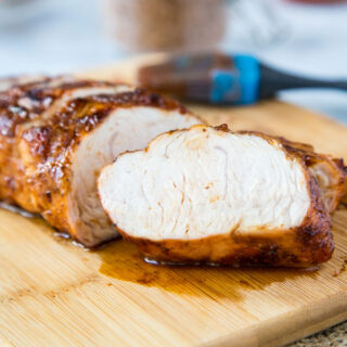 A piece of turkey sitting on top of a wooden cutting board