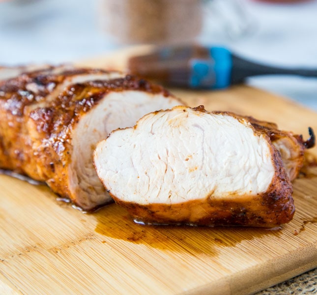 A piece of turkey sitting on top of a wooden cutting board