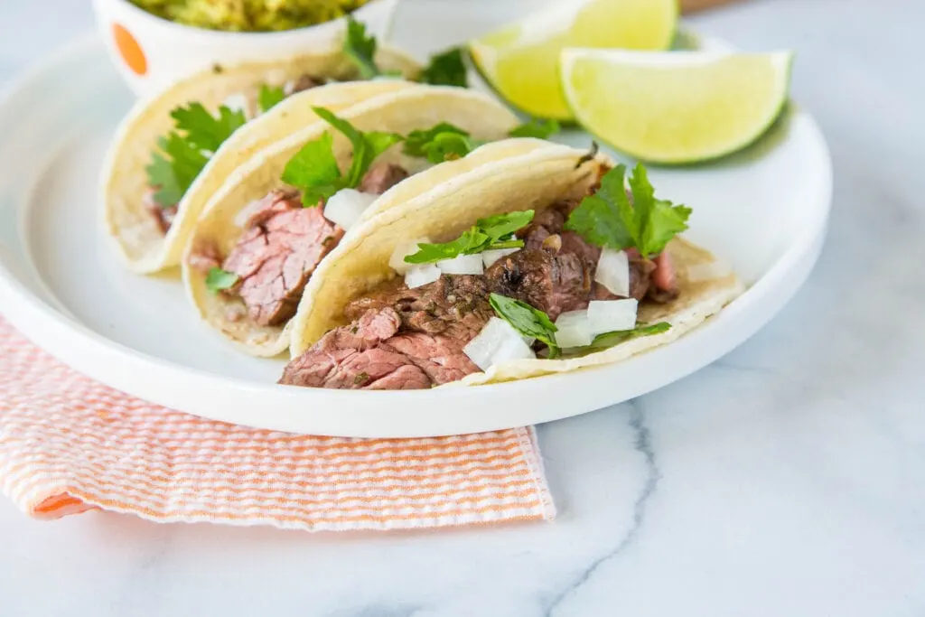 Tacos with flank steak marinated in lime juice, olive oil, garlic and cilantro