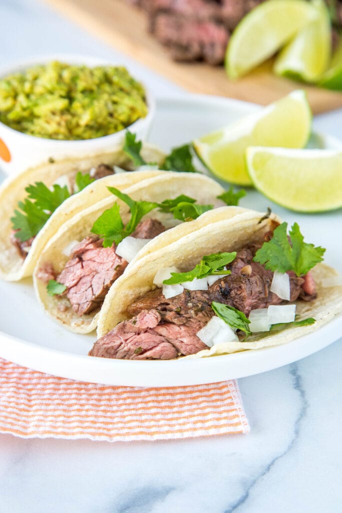 Flank Steak Tacos topped with onions and fresh cilantro