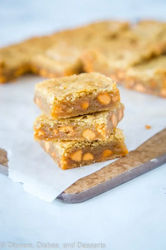 Butterscoth Blondies stacked on a cutting board. They are loaded with butterscotch chips and delicious!