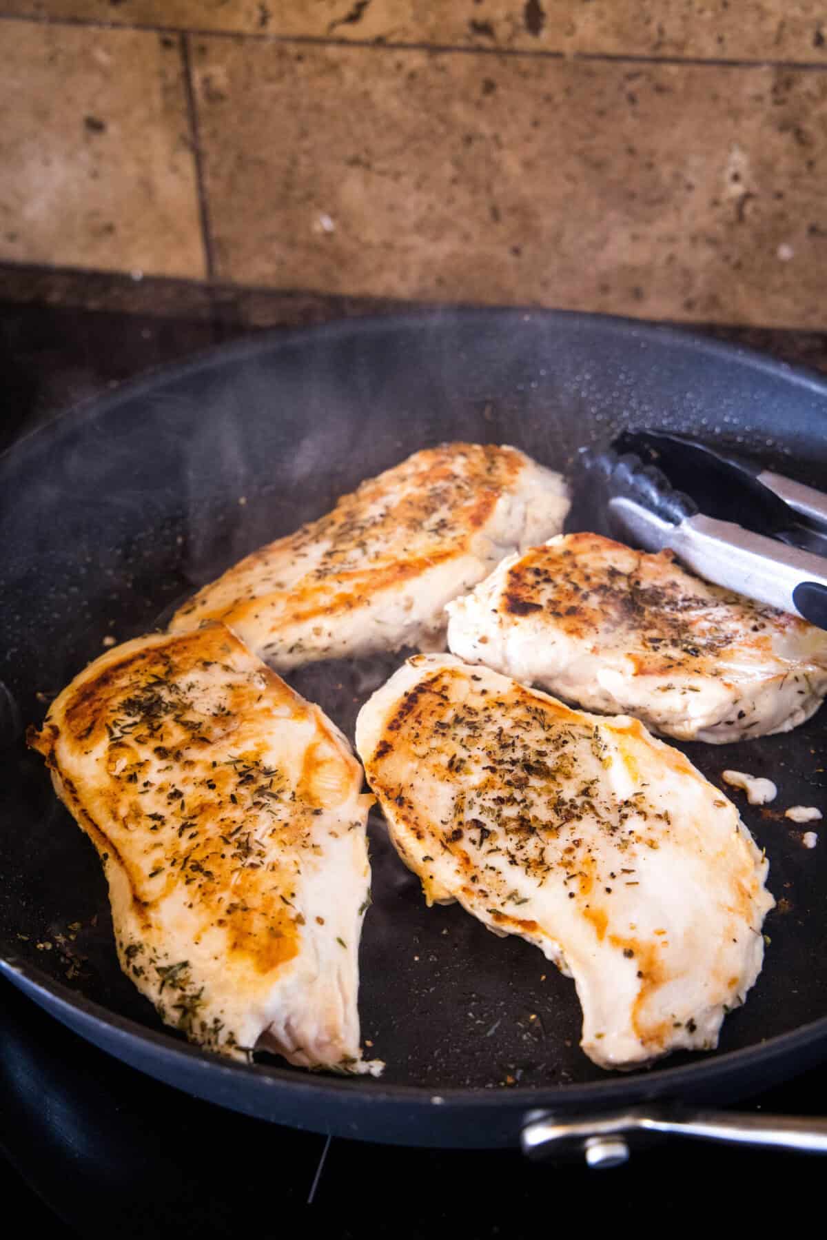 Seared chicken breasts in a skillet.