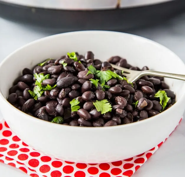 A bowl of black beans on a plate