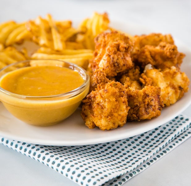 chick fil a chicken nuggets on a plate with fries and dipping sauce