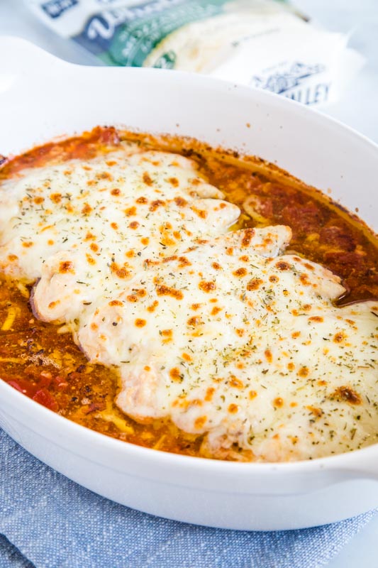 Easy Baked Chicken with garlic butter, diced tomatoes and lots of cheese