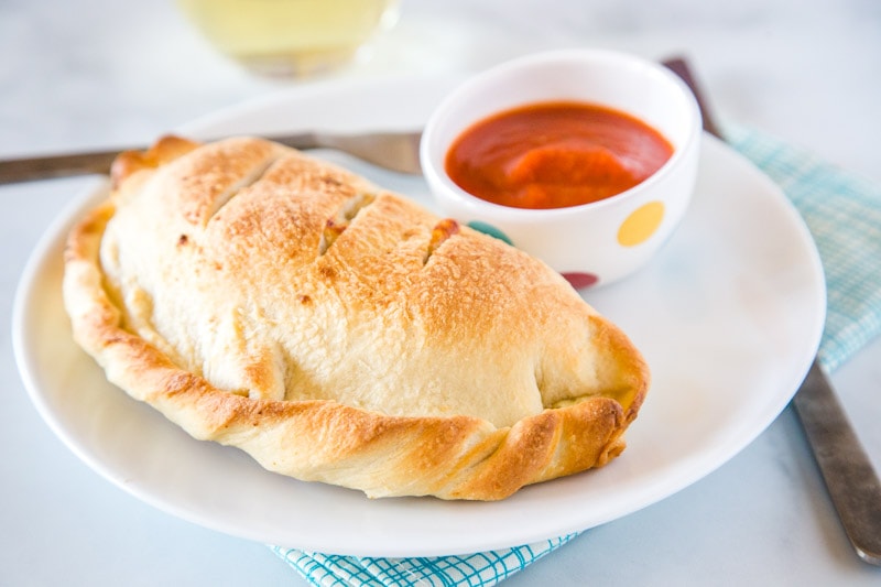 Homemade Calzones - Sausage and pepperoni mixed in a creamy cheese mixture and baked in a delicious and fluffy dough.  Absolutely delicious and everyone is going to go crazy for them! 