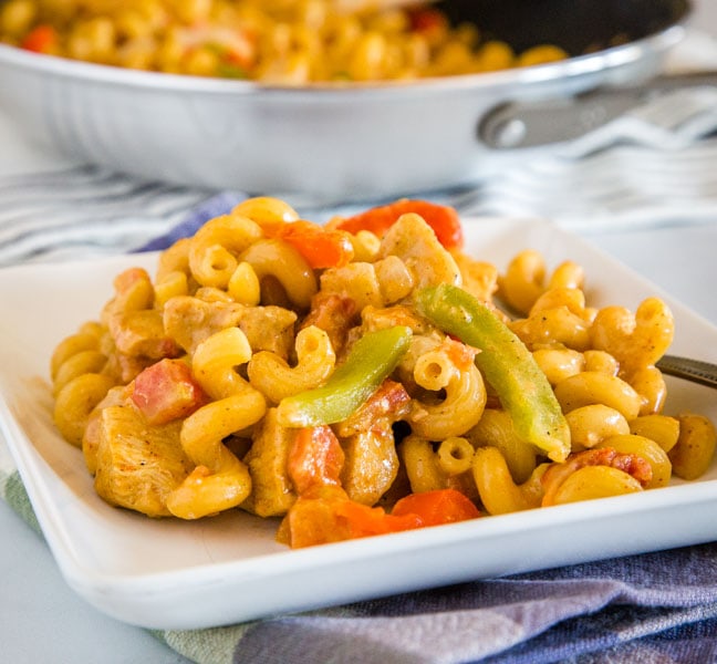 A bowl of food on a plate, with Chicken and Dinner