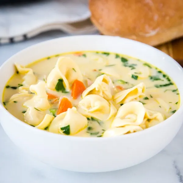 Creamy Chicken Tortellini Soup - A quick and easy soup that is perfect for a cold night.  Warm up with this cozy soup filled with vegetables, chicken and tortellini all in a delicious creamy broth. 