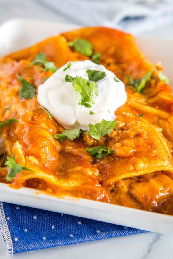 Easy Ground Beef Enchiladas - easy enchiladas filled with seasoned ground beef, onions, and lots of cheese! Absolutely delicious with just a few simple ingredients. Get a restaurant quality dinner on the table for dinner tonight!Â