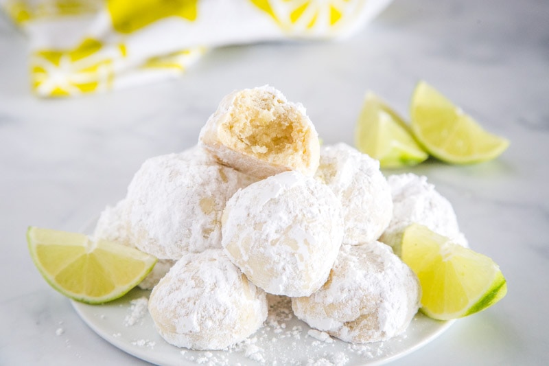 Lime Cooler Cookies - Sweet, buttery, melt in your mouth cookies flavored with lots of lime and coated in powdered sugar. They are light and fluffy and perfect all year round!