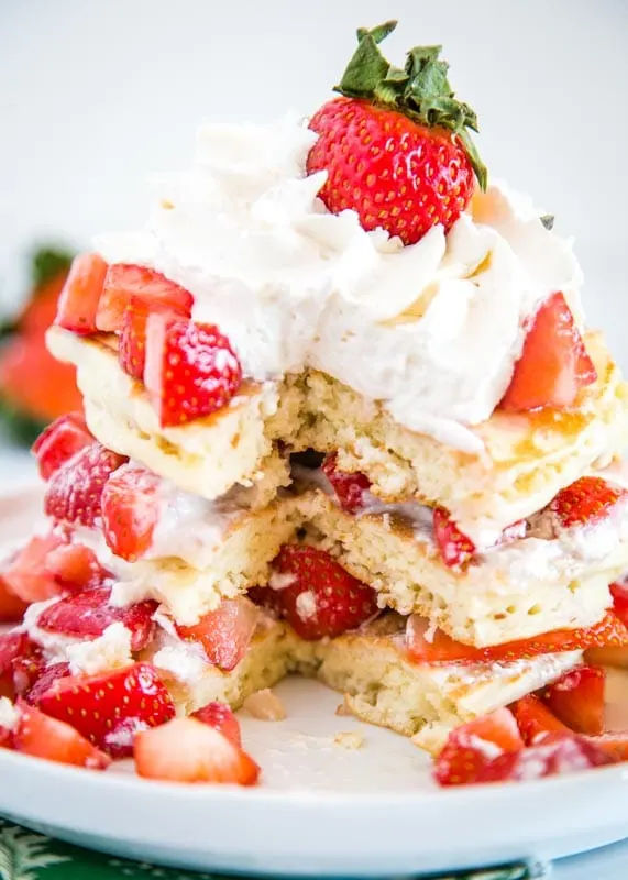 Light and fluffy pancakes with whipped cream and fresh juicy strawberries