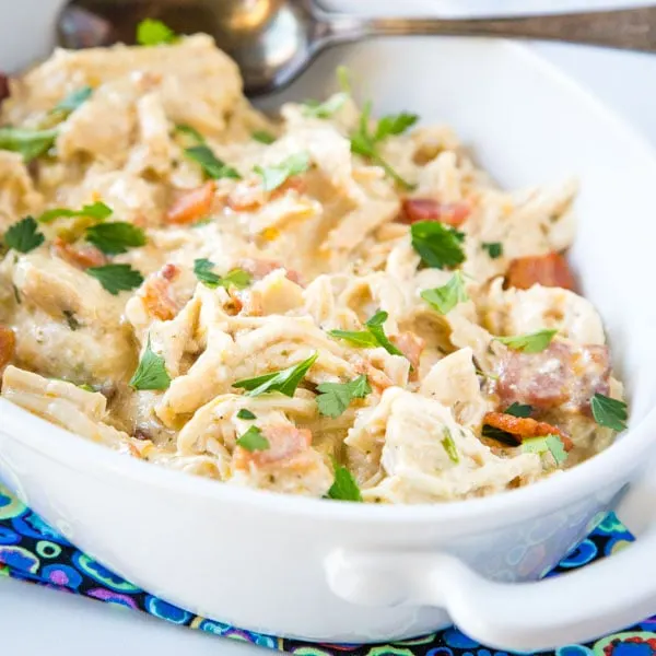 A bowl of food on a plate, with Chicken and Dinner