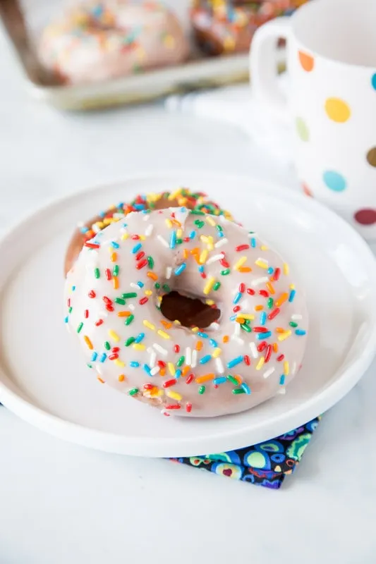 Raised donuts with white icing and sprinkles