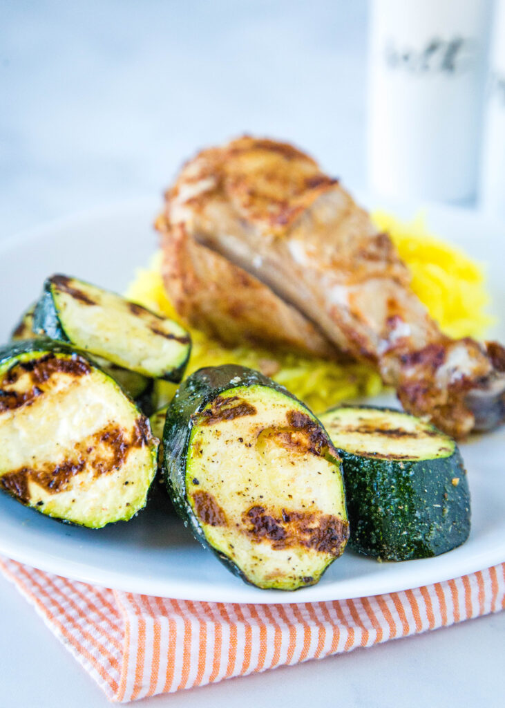 zucchini with grilled chicken and rice on a white plate