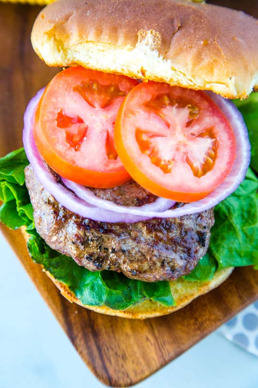 The best homemade hamburgers for summer. Toasted bun with tomatoes, onion and lettuce