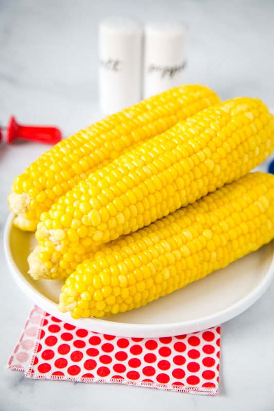 instant pot corn on the cob stacked on a white plate