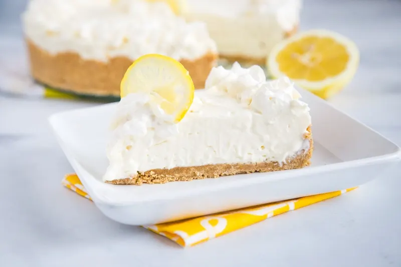 No Bake Lemon Cheesecake - sweet, tart, smooth, and super creamy cheesecake with lots of lemon flavor.  This lemon cheesecake uses lemon juice and lemon zest and is ready in minutes without having to turn on the oven!