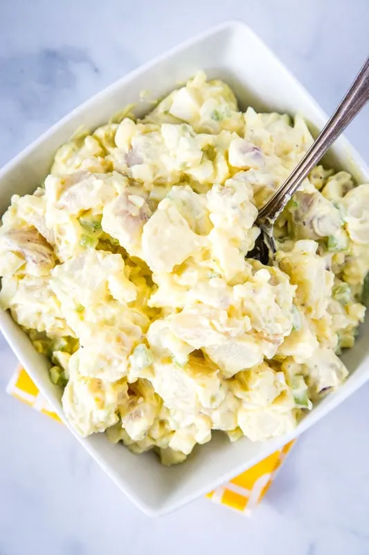 easy potato salad recipe in white bowl with a spoon
