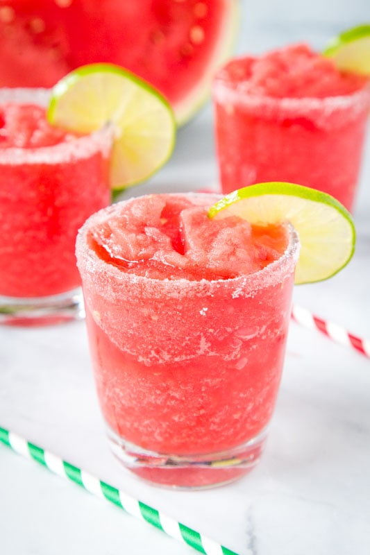 glasses filled with watermelon margarita and a slice of lime