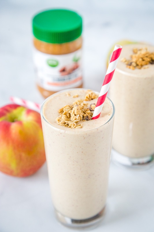 apple smoothie in a glass with a straw