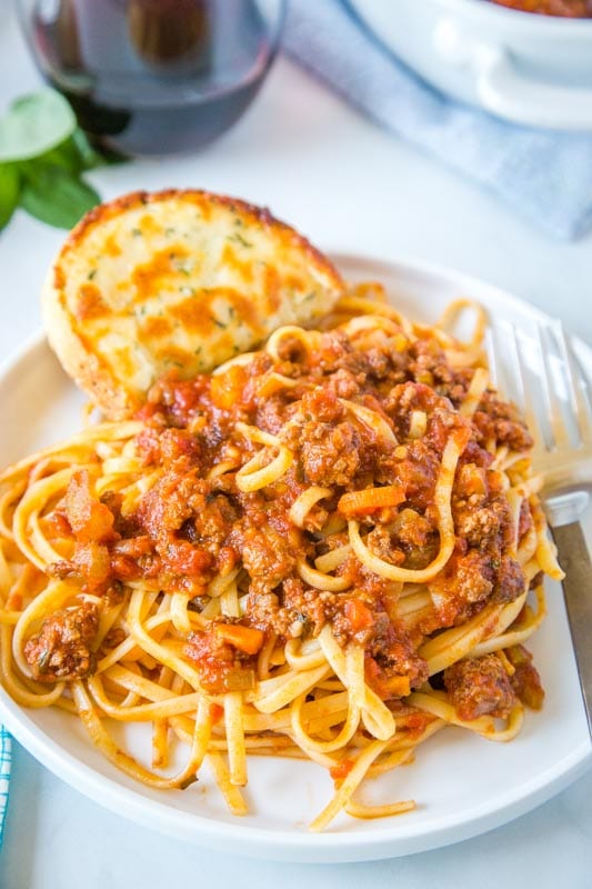 pasta with italian meat sauce on a plate with fork