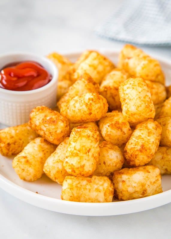 Air fryer tater tots on a plate with ketchup