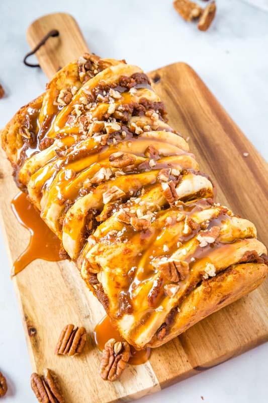 pull apart bread with caramel and pecans on wood cutting board