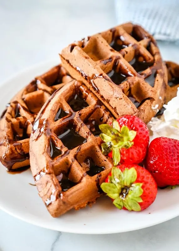 pieces of chocolate waffle with strawberries on a plate