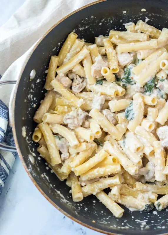 chicken and spinach alfredo in a skillet