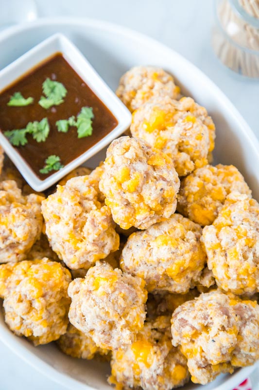 cream cheese sausage balls in white dish with barbecue sauce