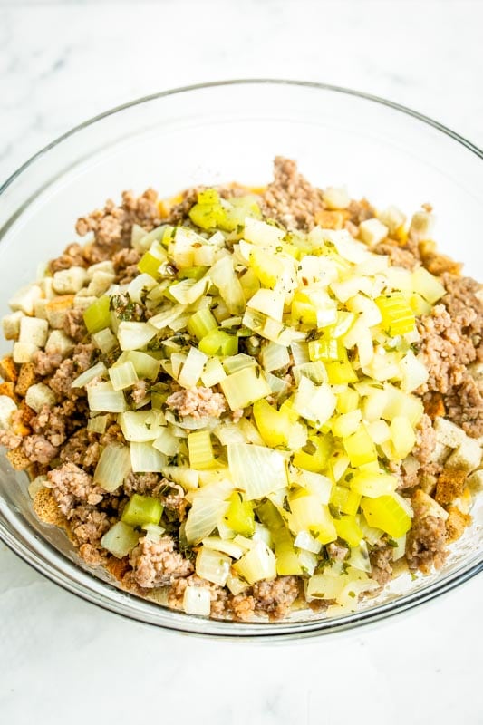 celery, onions and sausage in a bowl