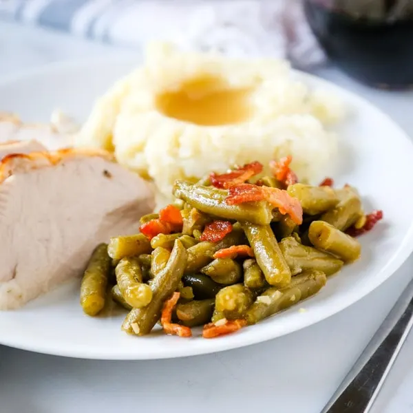 cropped picture of green beans on plate with turkey and potatoes