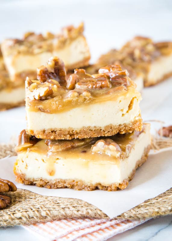 praline cheesecake bars staked on white paper