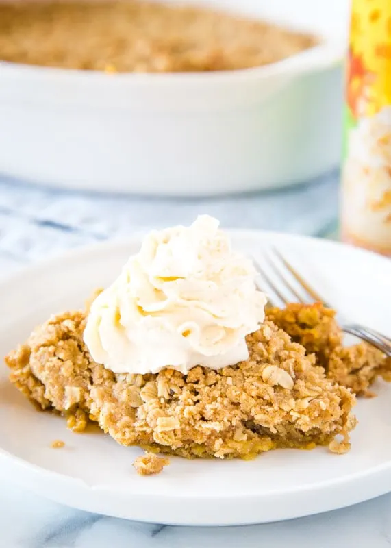 pumpkin crisp on plate topped with whipped cream