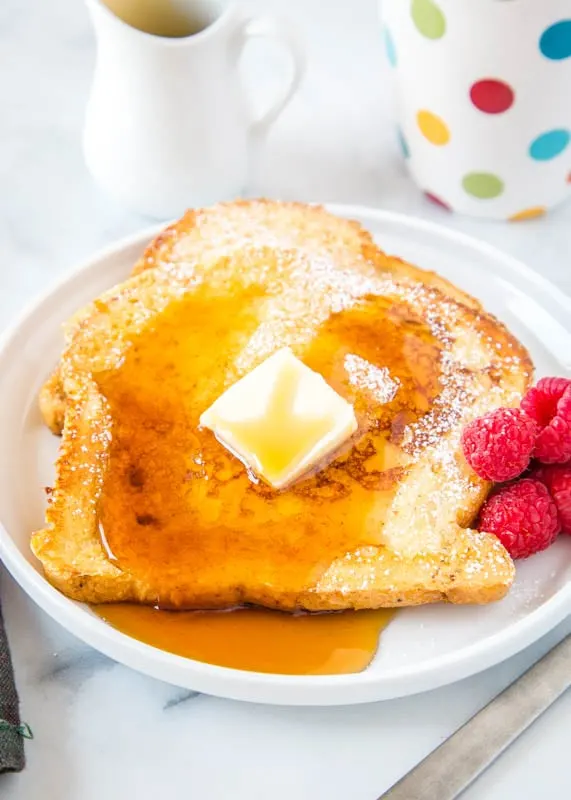 french toast on plate with butter and syrup on top