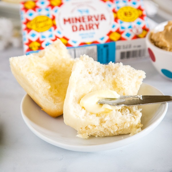 cropped image of butter being spread on a roll