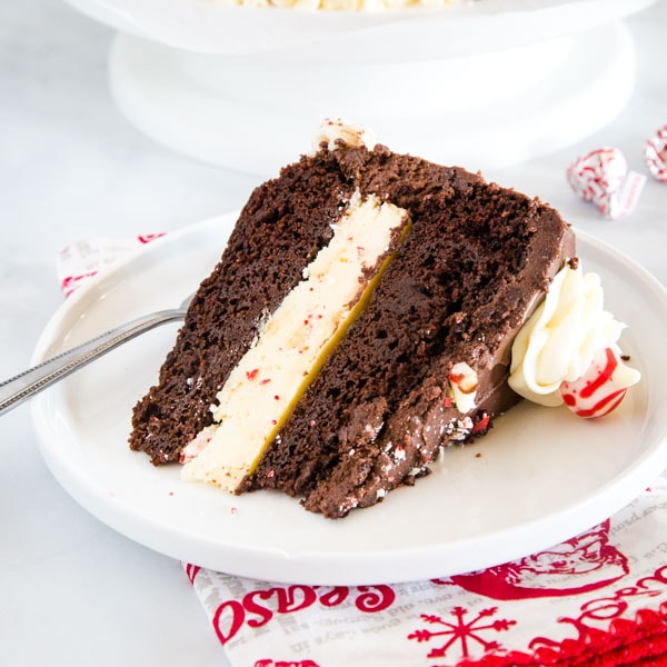 Chocolate Peppermint Cheesecake Cake - Rich chocolate cake with a layer of peppermint cheesecake in the middle and coated in a delicious chocolate frosting. This show stopping dessert will definitely impress during the holidays.