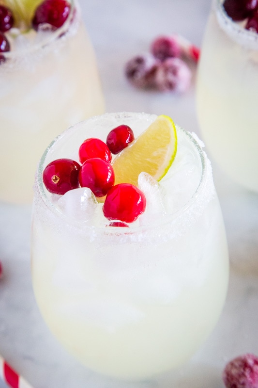 white christmas margarita with lime wedge and cranberries